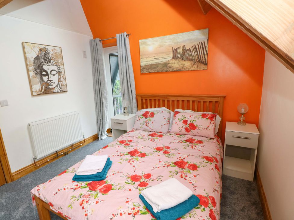 A bedroom with a bed and bedside table at Pendre Barn Llanfyrnach