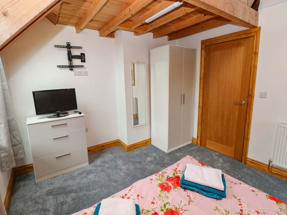 A bedroom with a bed and television at Pendre Barn Llanfyrnach