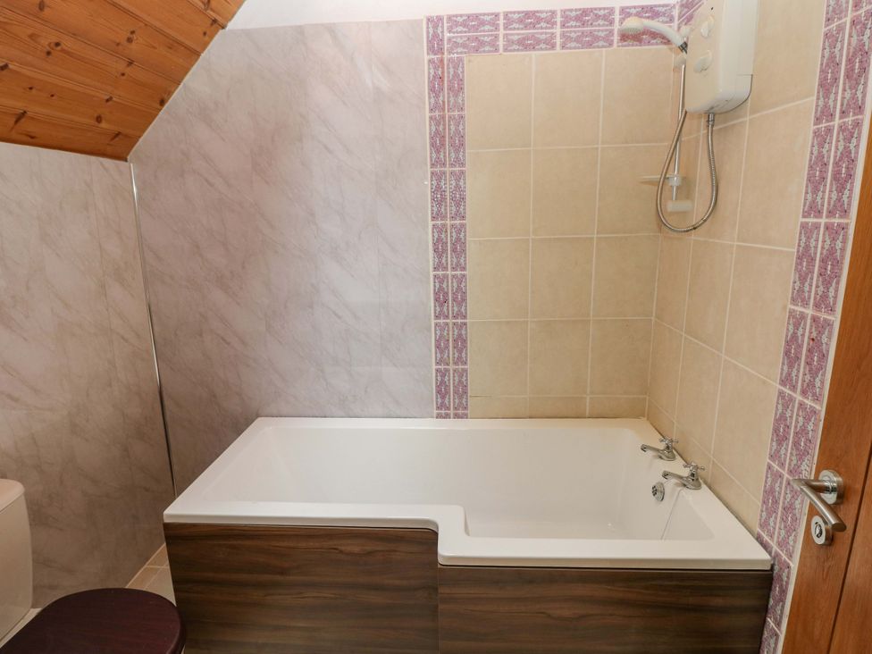 A bathroom with a bath tub and shower at Pendre Barn in Llanfyrnach