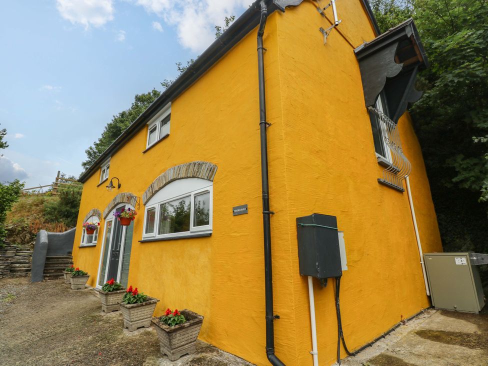 A yellow house with flower planters at Pendre Barn Llanfyrnach