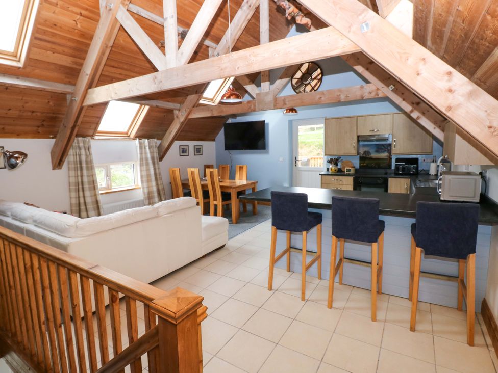 A living room with a kitchen and dining area at Pendre Barn Star near Cenarth