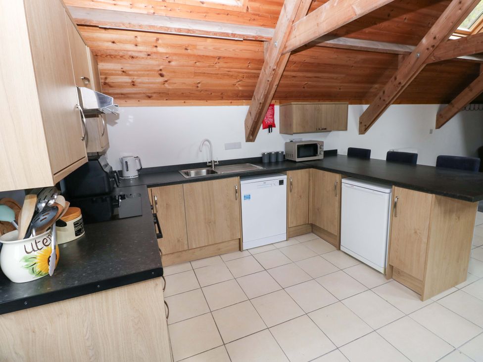 A kitchen with wooden cabinets and appliances at Pendre Barn in Star near Cenarth