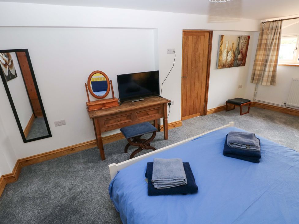 A bedroom with a bed and a desk at Pendre Barn Star near Cenarth