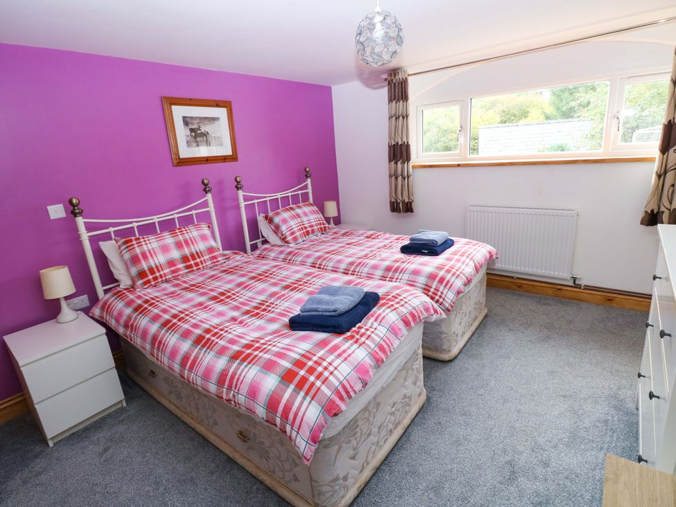 A bedroom with twin beds and a window at Pendre Barn Star near Cenarth