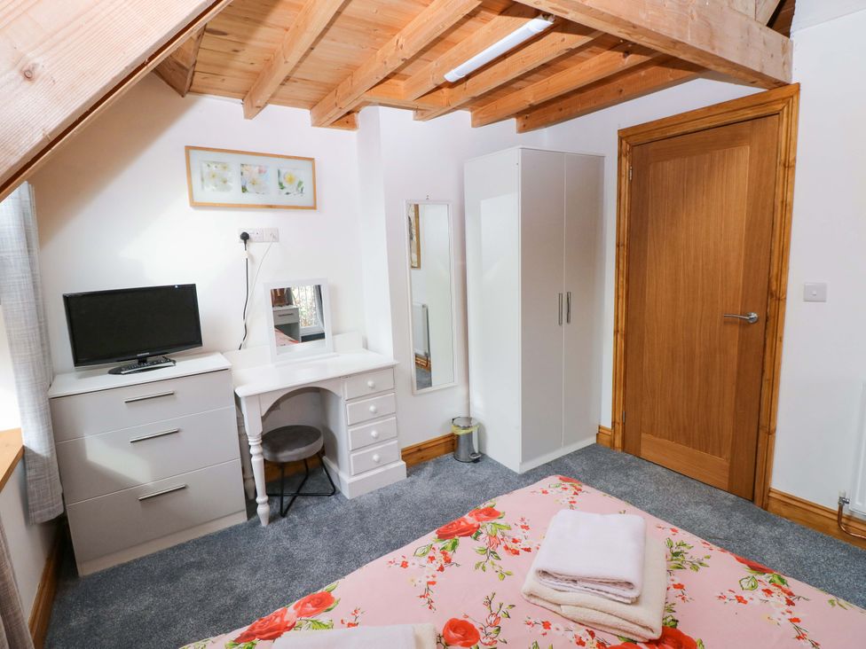 A bedroom with a television and a wardrobe at Pendre Barn near Star near Cenarth