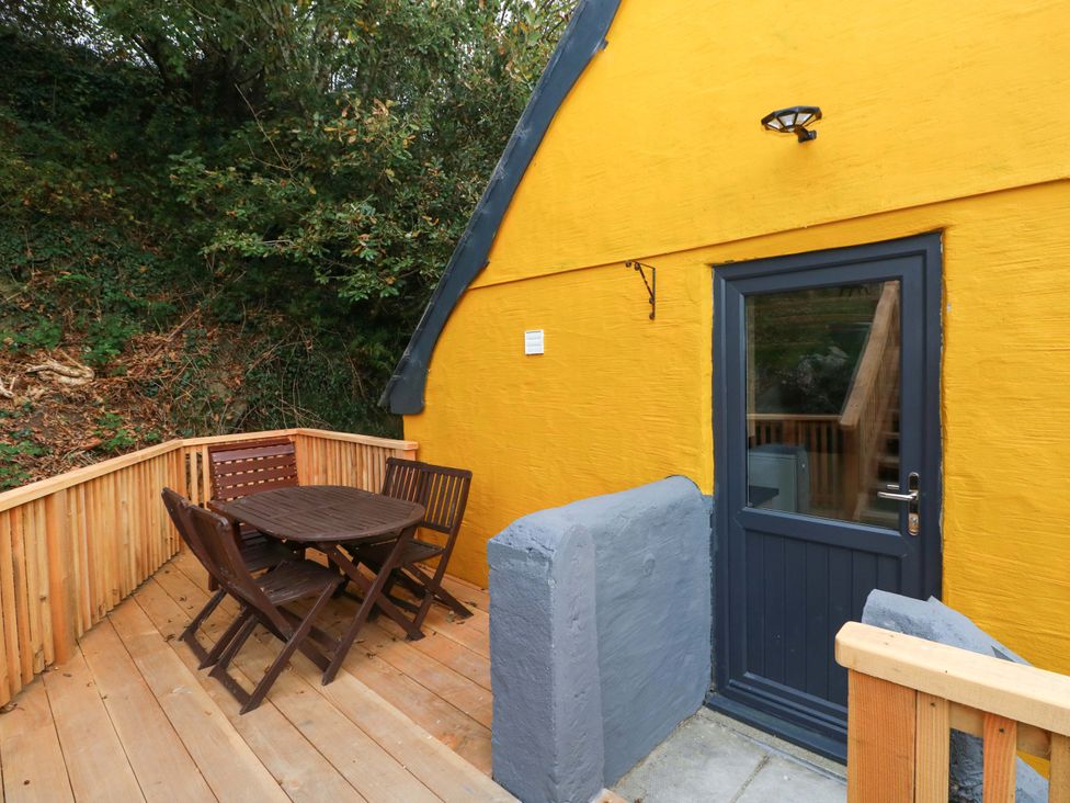 An outdoor seating area with a table and chairs at Pendre Barn Star near Cenarth