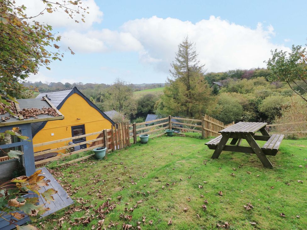 A garden with a picnic table and planters at Pendre Barn Star near Cenarth