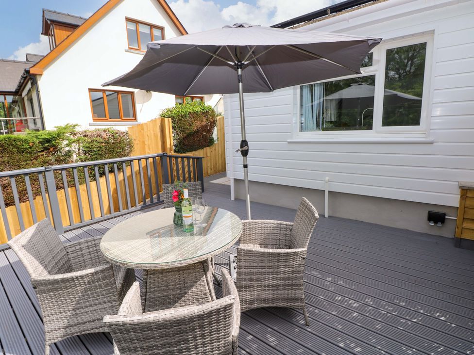 An outdoor patio with a table and chairs at Pinecroft Annex Stepaside near Saundersfoot