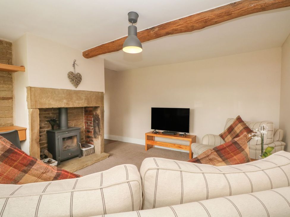 A living room with a fireplace and television at Cottage Round T'Corner Holmfirth