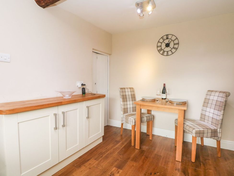 A dining room with a table and chairs at Cottage Round T'Corner Holmfirth