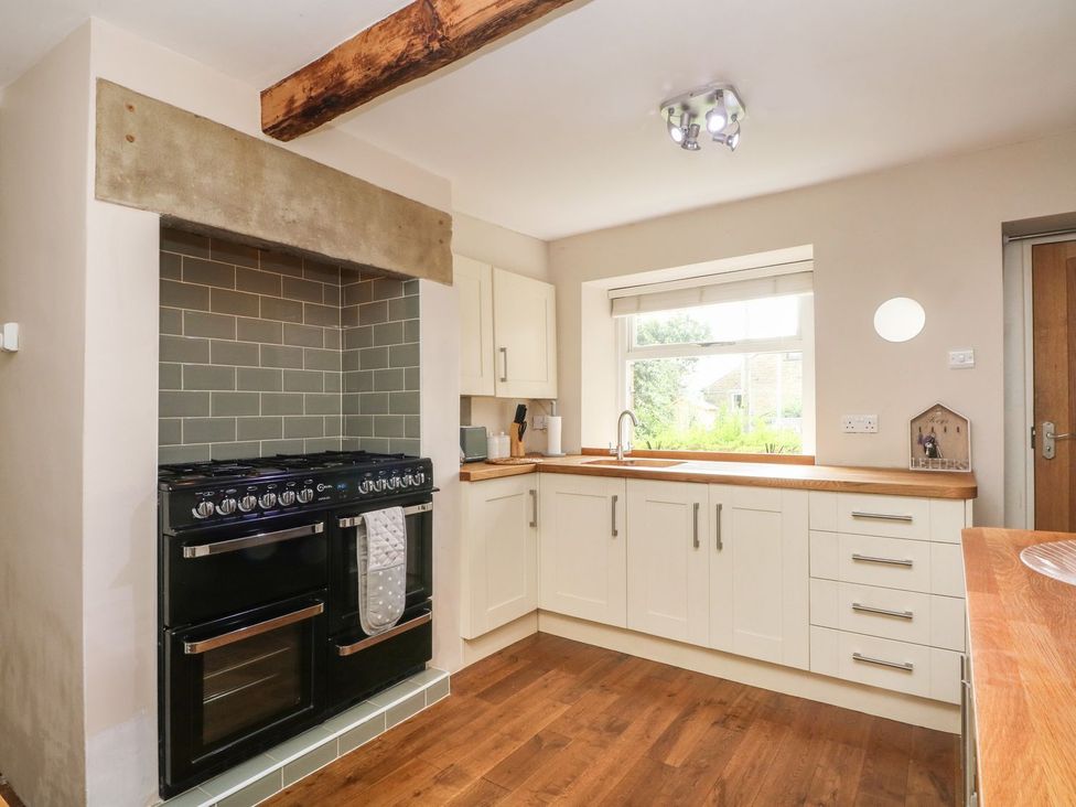 A kitchen with a stove and sink at Cottage Round T'Corner in Holmfirth