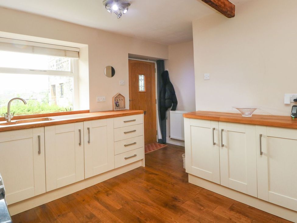 A kitchen with a sink and cabinets at Cottage Round T'Corner in Holmfirth