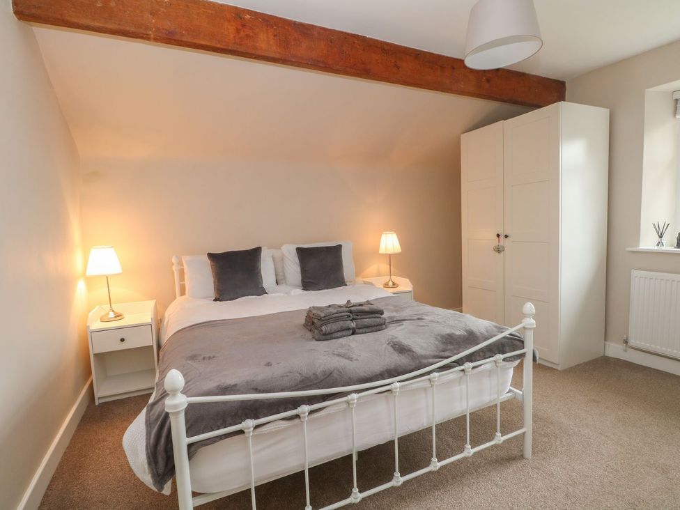 A bedroom with a bed and wardrobe at Cottage Round T'Corner Holmfirth