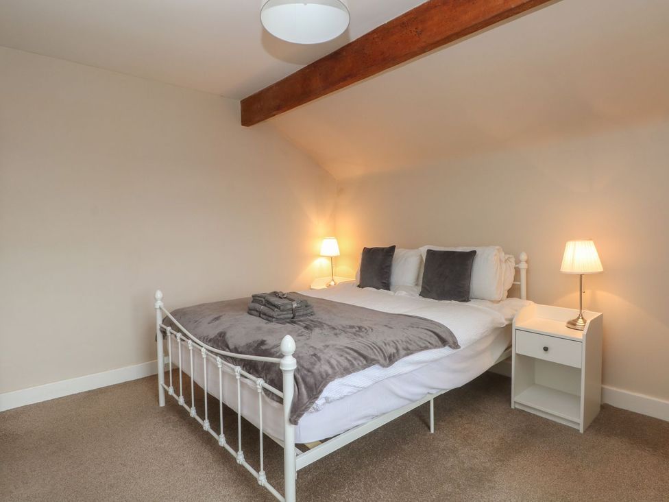 A bedroom with a bed and bedside tables at Cottage Round T'Corner Holmfirth