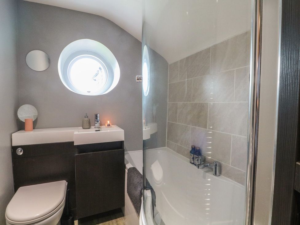A bathroom with a bathtub and sink at Cottage Round T'Corner in Holmfirth