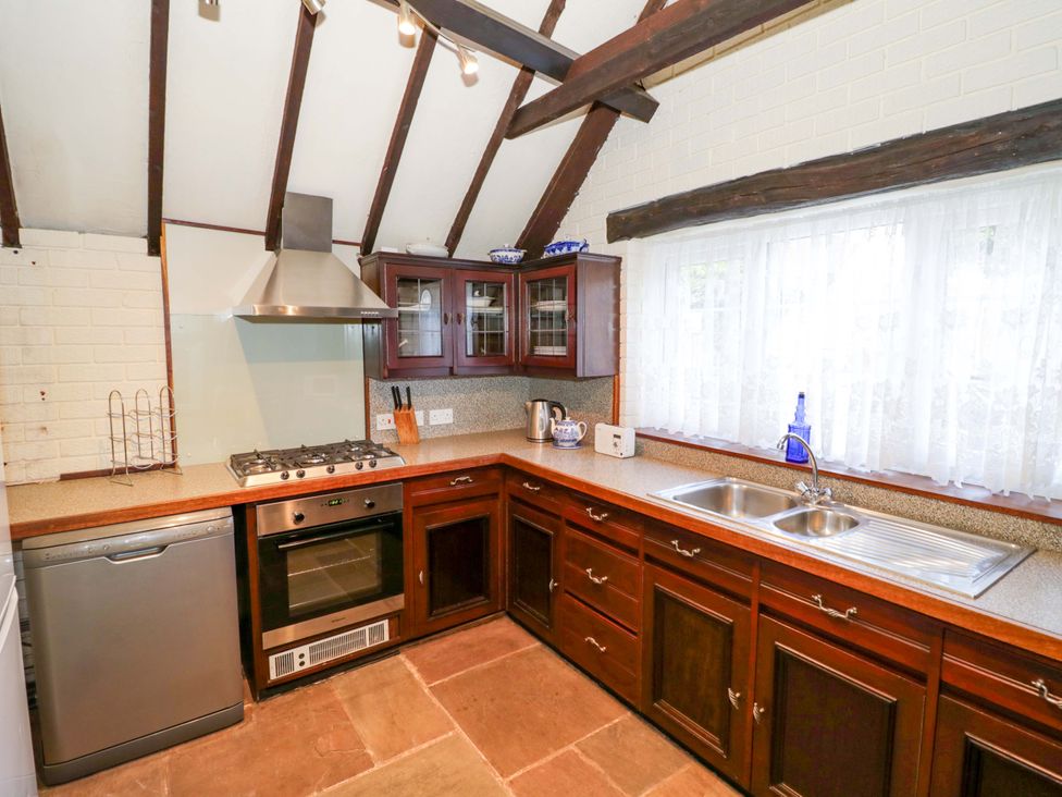 A kitchen with appliances and cabinets at Fern Cottage