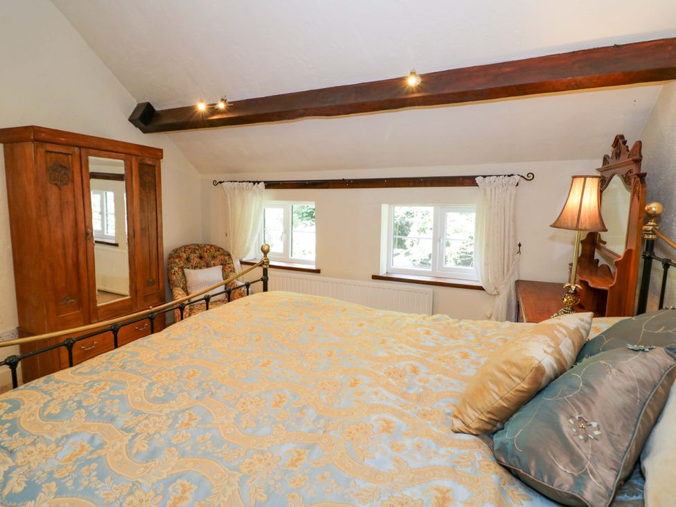 A bedroom with a bed and wardrobe at Fern Cottage