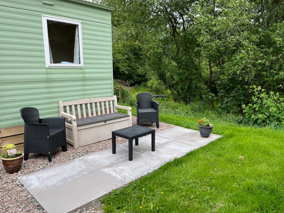 An outdoor seating area with a table and chairs at Sylvan in Builth Wells