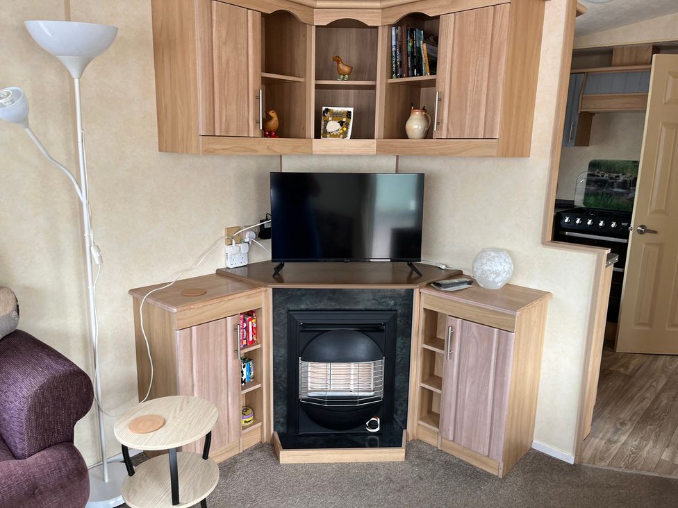 A snug with a television and fireplace at Sylvan in Builth Wells