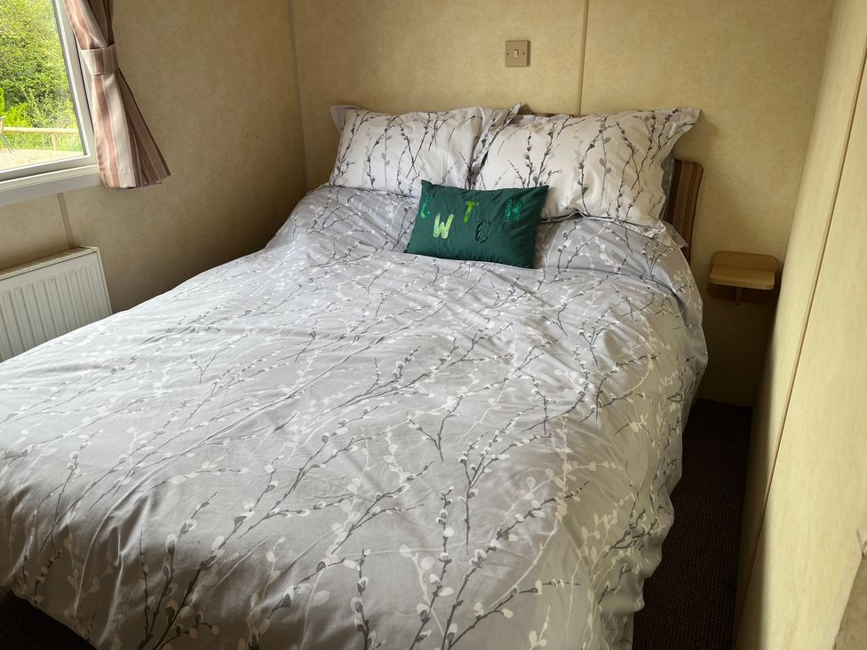 A bedroom with a bed and pillows at Sylvan in Builth Wells