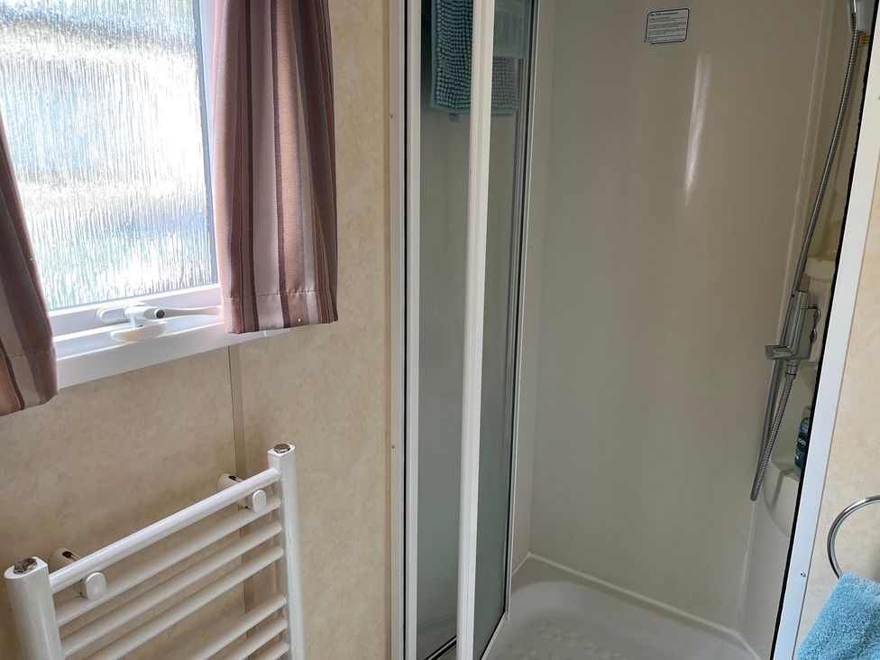 A bathroom with a shower and towel rack at Sylvan in Builth Wells