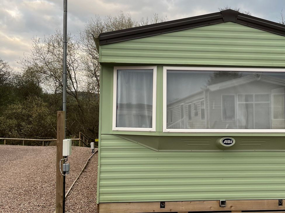 A static caravan exterior with a window and door at Sylvan in Builth Wells