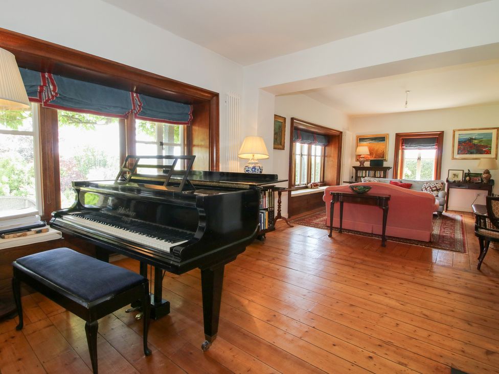 A living room with a piano and a sofa at Uplands House in Ledbury