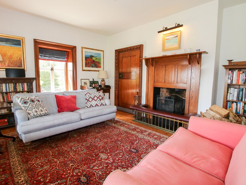 A living room with a fireplace and bookshelf at Uplands House in Ledbury