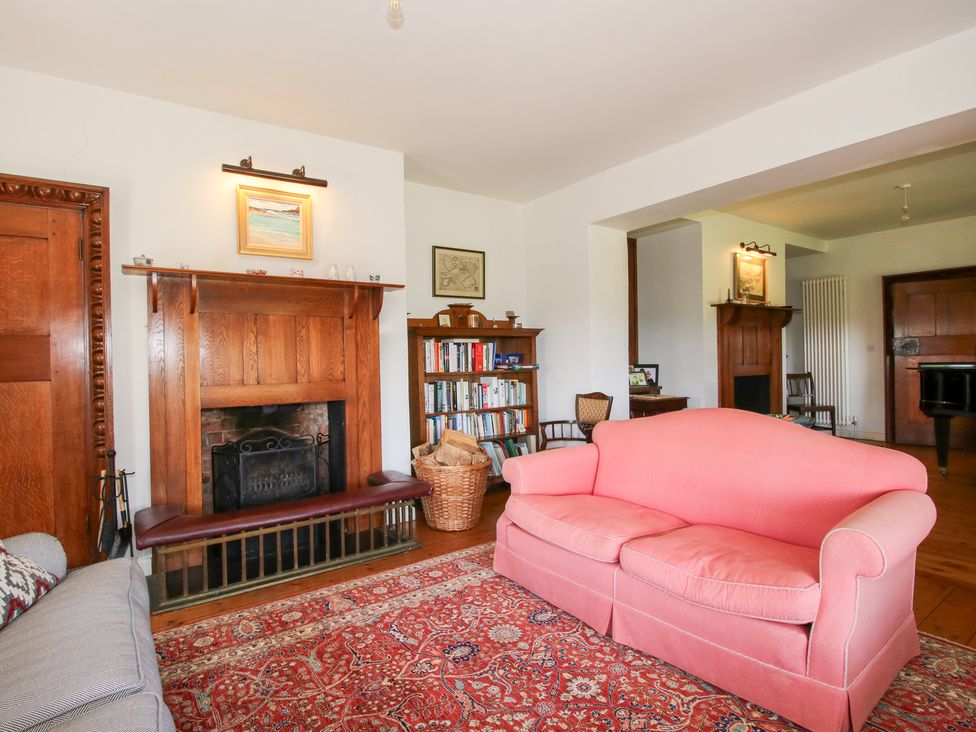 A living room with a fireplace and bookshelf at Uplands House in Ledbury