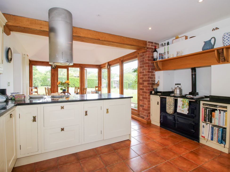 A kitchen with a stove and island at Uplands House in Ledbury