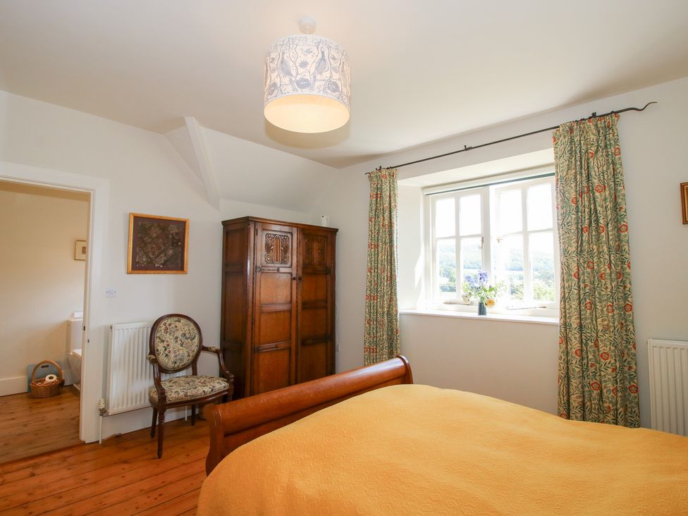 A bedroom with a bed and wardrobe at Uplands House in Ledbury