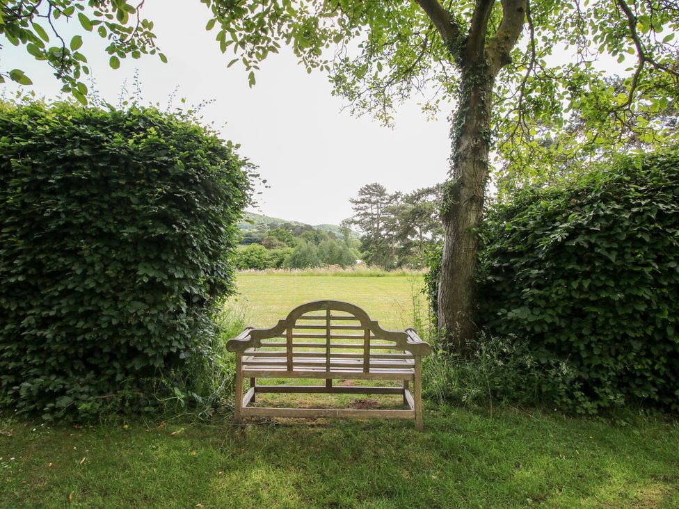A bench situated between hedges in a garden at Uplands House Ledbury