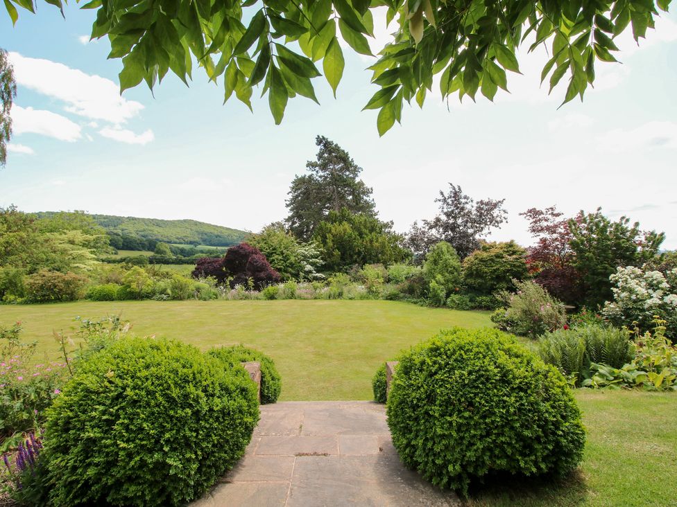 A garden with lawn and bushes at Uplands House in Ledbury
