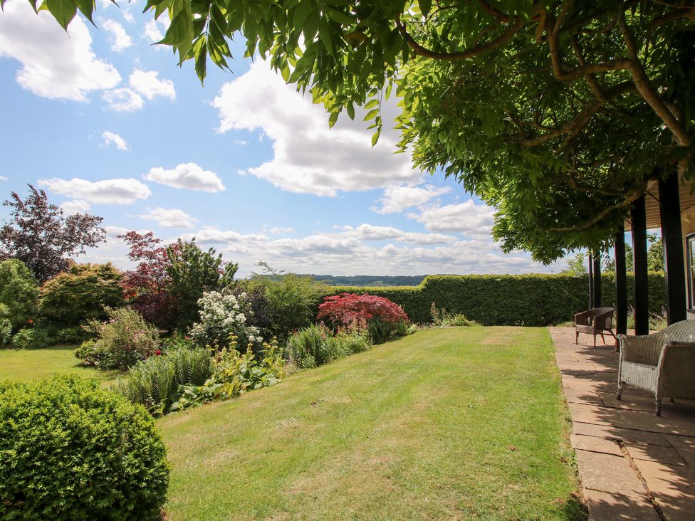 A garden with flowering plants and a pathway at Uplands House in Ledbury