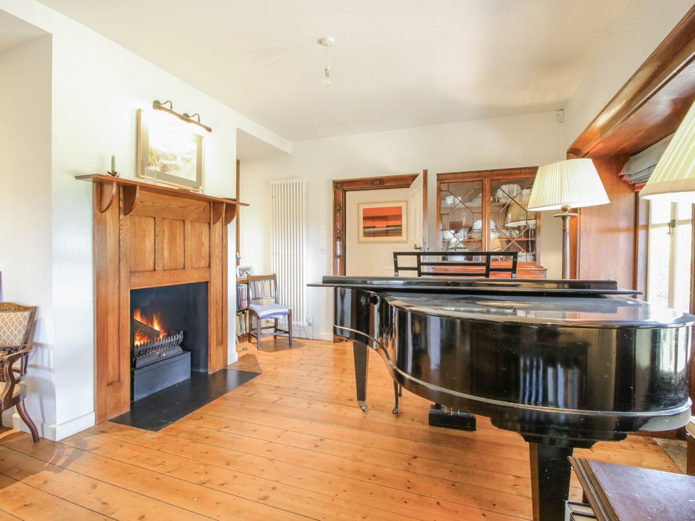 A living room with a grand piano and fireplace at Uplands Dowerhouse Wellington Heath near Ledbury