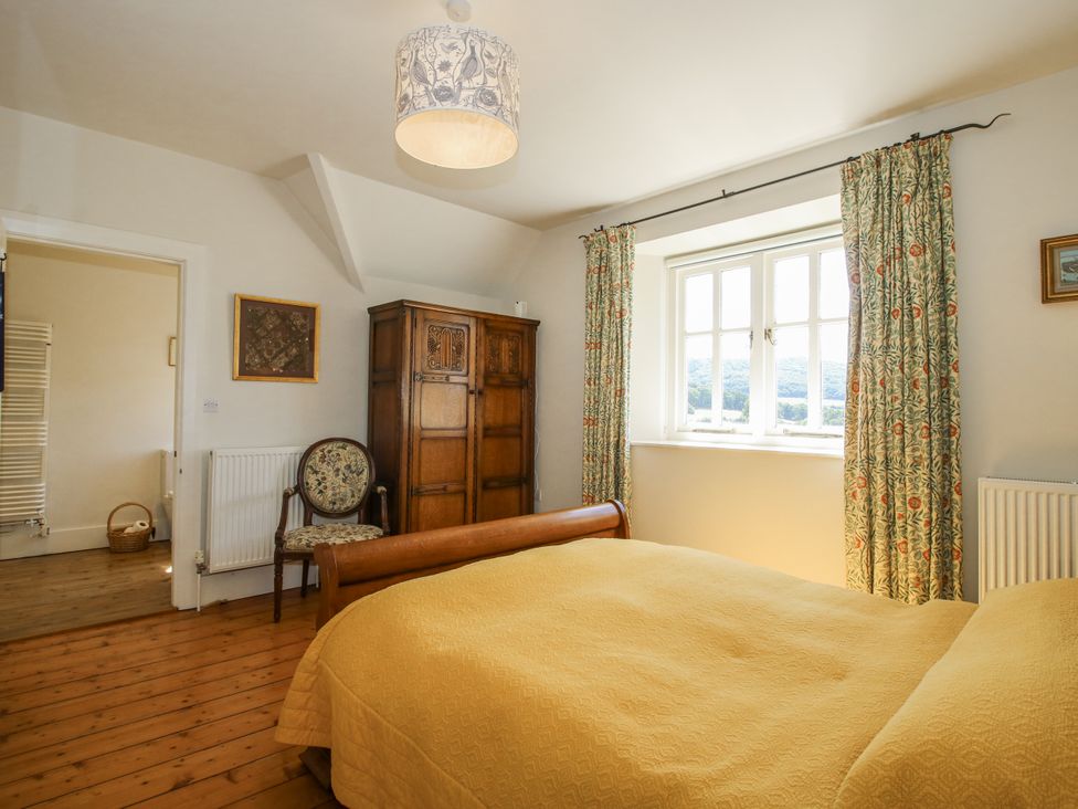 A bedroom with a bed and wardrobe at Uplands Dowerhouse in Wellington Heath near Ledbury