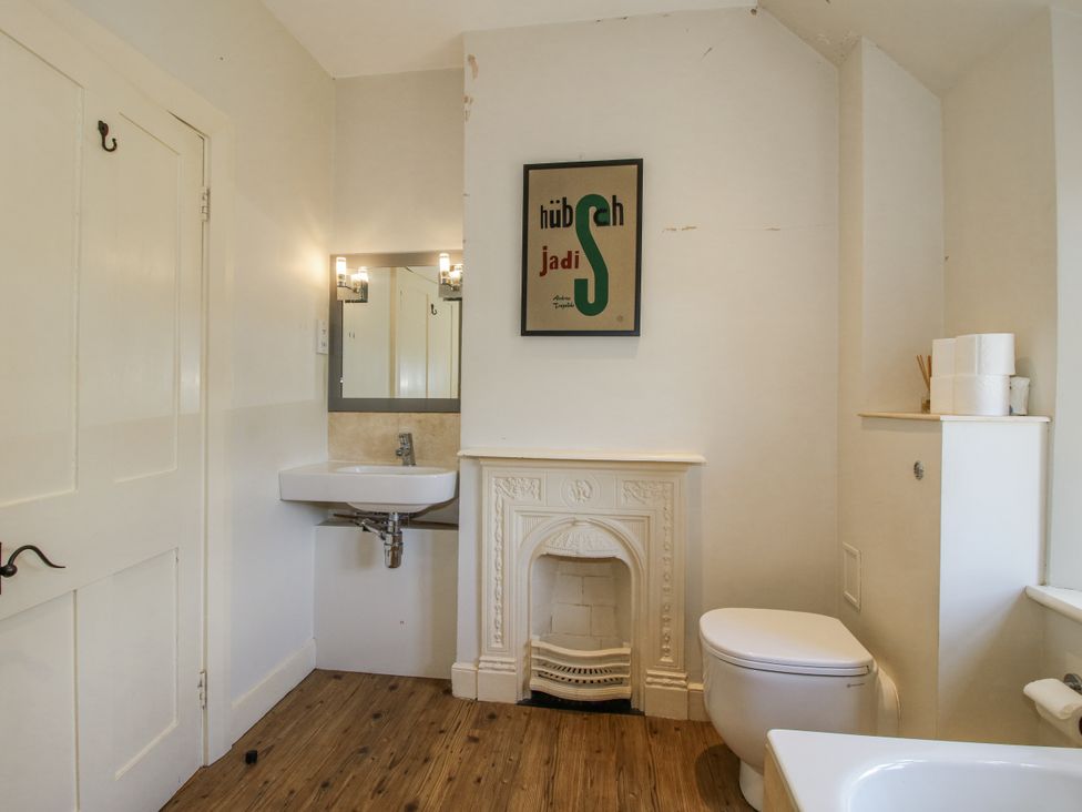A bathroom with a sink, toilet, and a mirror at Uplands Dowerhouse Wellington Heath near Ledbury