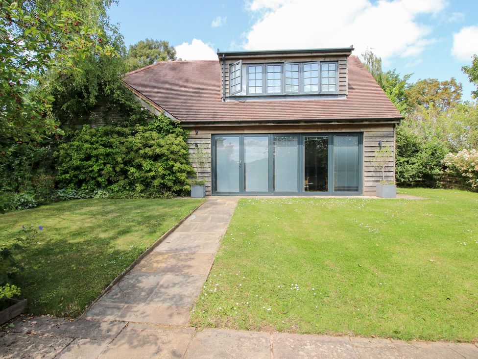 A house with grass and a stone pathway at Uplands Cottage in Ledbury