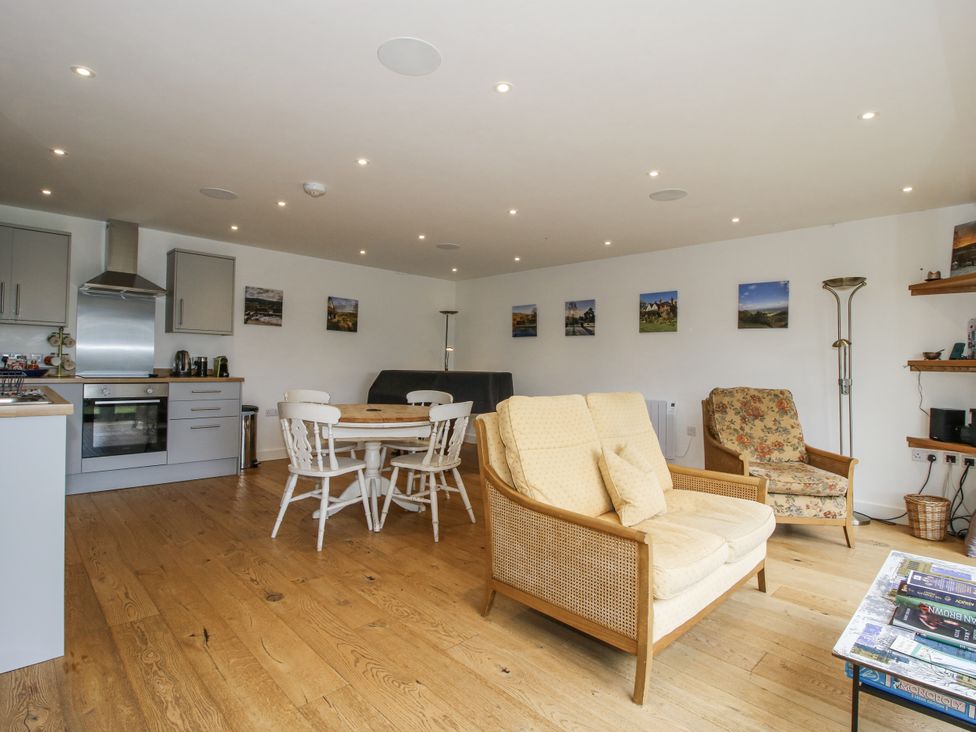 A living room with kitchen units and dining table at Garden Cottage in Wellington Heath near Ledbury