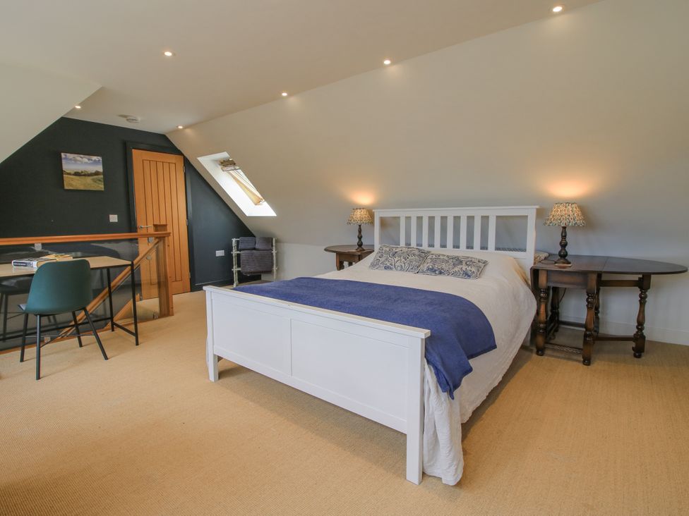 A bedroom with a bed and desk at Garden Cottage in Wellington Heath near Ledbury