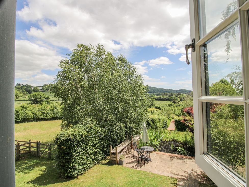 A garden view featuring a table and chairs at Garden Cottage Wellington Heath near Ledbury