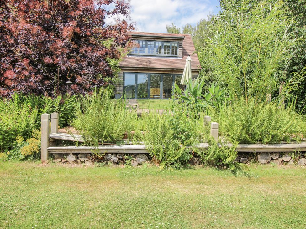 A house with a garden and ferns at Garden Cottage in Wellington Heath near Ledbury