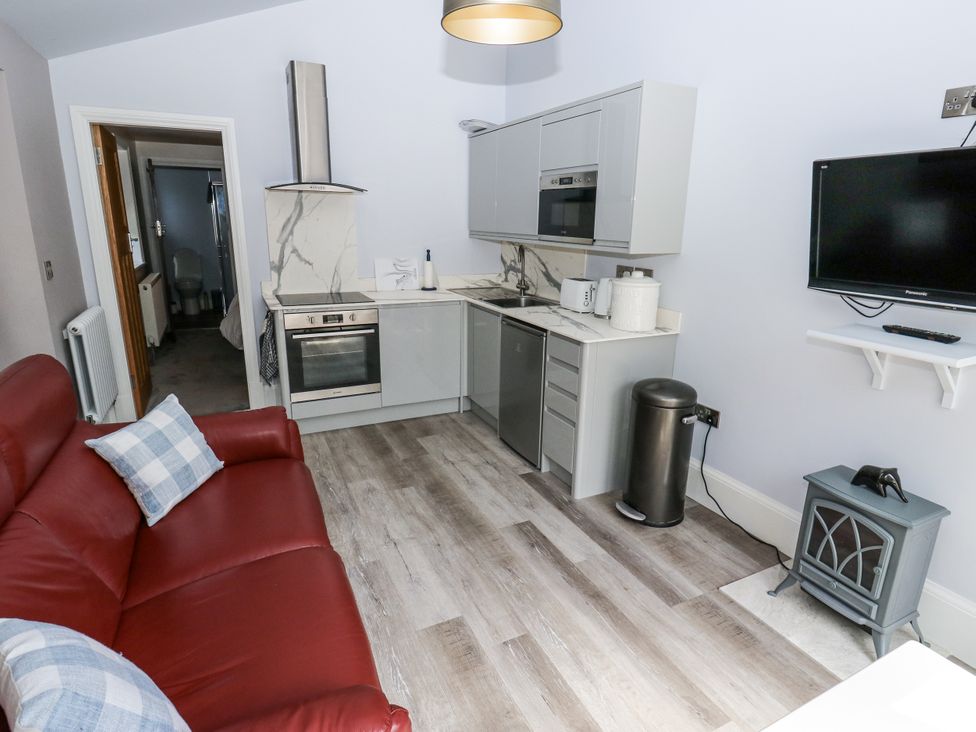 A kitchen with a couch and appliances at Little Birchinlea Glossop