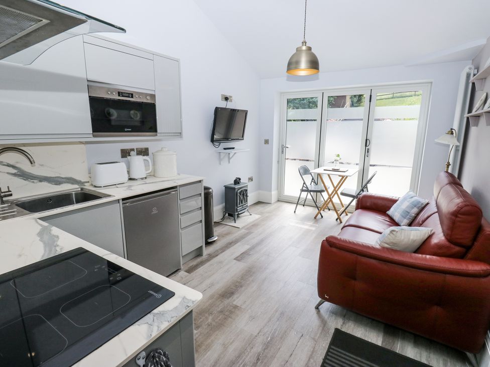 A kitchen with modern appliances and a seating area at Little Birchinlea in Glossop