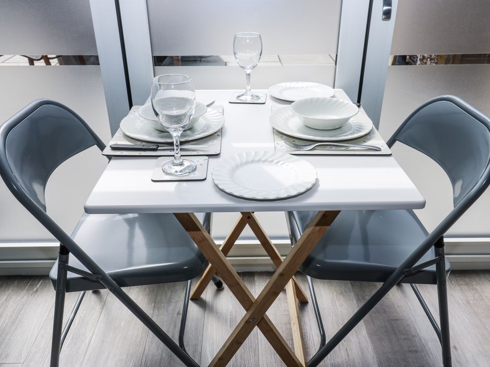 A dining table set with plates and glasses at Little Birchinlea in Glossop