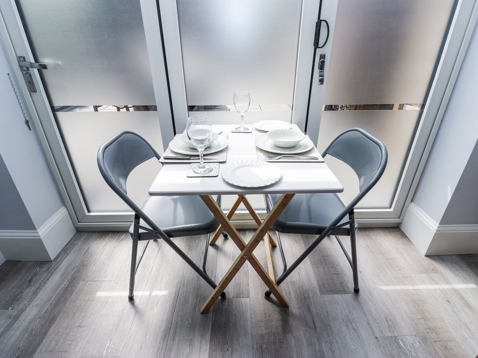 A dining table with two chairs and dining utensils at Little Birchinlea in Glossop