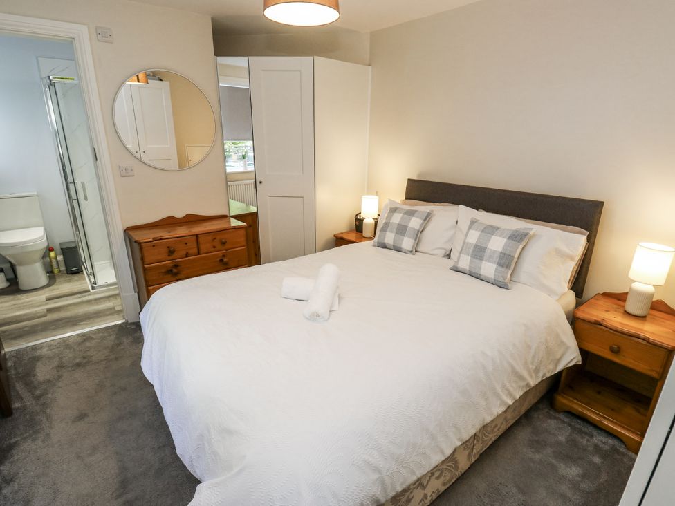 A bedroom with a bed and bathroom access at Little Birchinlea in Glossop