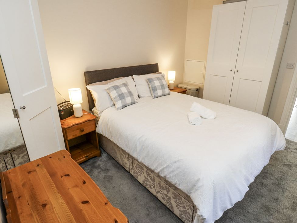 A bedroom with a bed and a nightstand at Little Birchinlea in Glossop