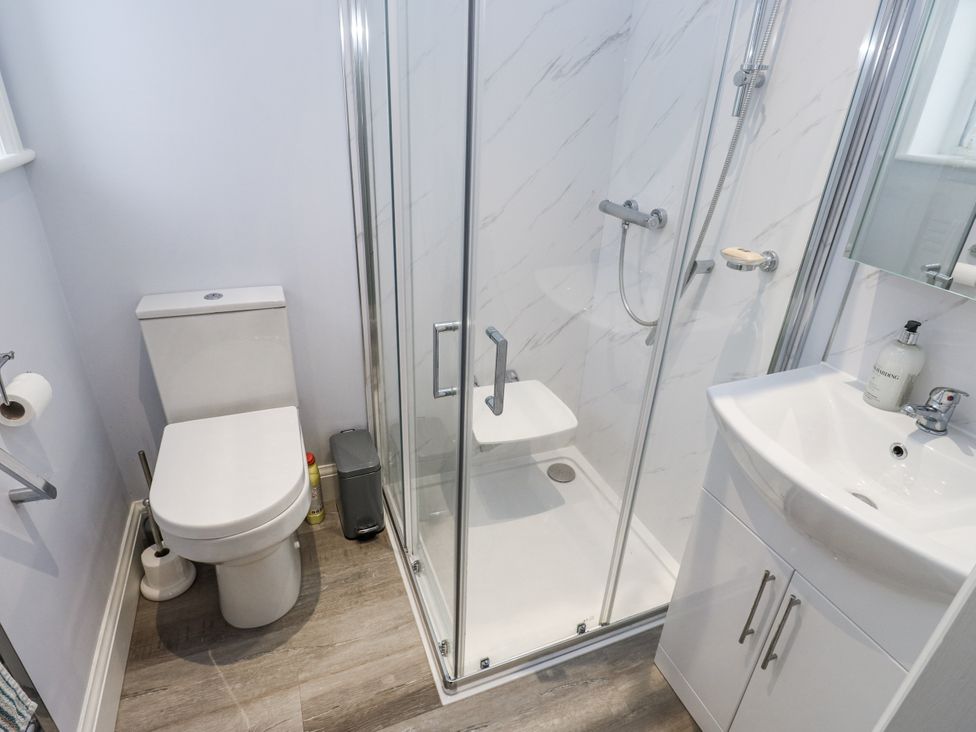 A bathroom with a toilet, shower, and sink at Little Birchinlea in Glossop