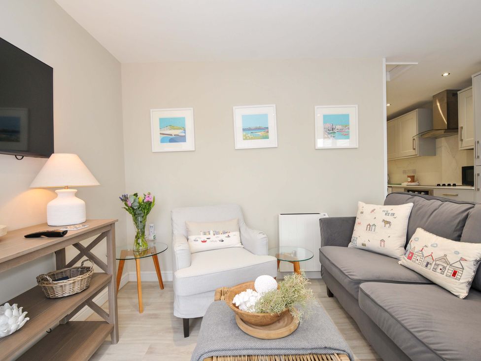 A living room with a sofa and armchair at Evelyn in Looe